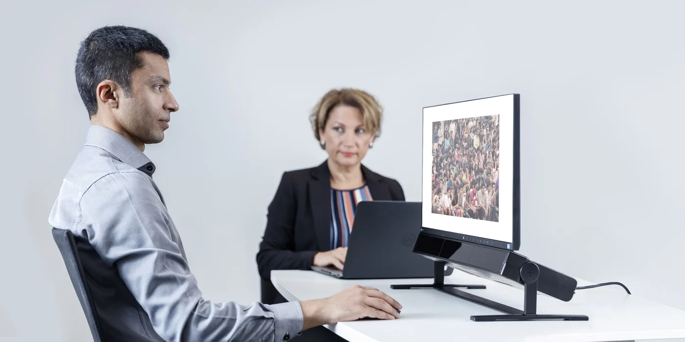 Stanowisko badawcze z eye trackerem Tobii Pro Spectrum — uczestniczka przed monitorem, badaczka obserwuje przebieg badania